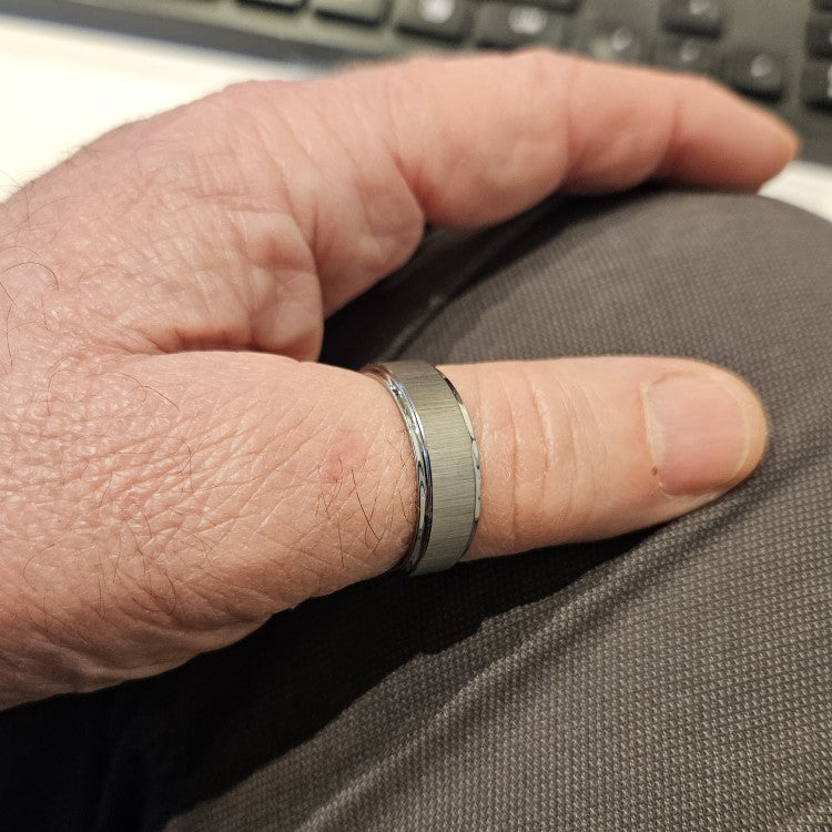 8mm Silver Tungsten Carbide Ring with cross satin finish and polished edges on finger.