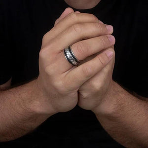 Hoxton silver ring for men worn on finger with detailed pattern on black background