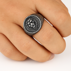 Antique lion head ring on a finger, featuring bold relief detail and antique finish.