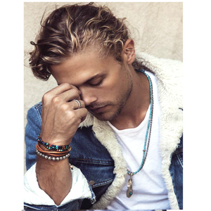 Multi-wrap beaded bracelet and necklace with turquoise, red jasper, blue lapis, hematite, and onyx stones worn by a person.