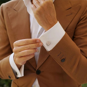 Engraved square cufflinks for men on white shirt cuff paired with brown suit jacket
