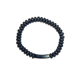 Black lava bead bracelet with stainless steel accent from T.M.J, featuring textured lava stones and sleek metallic details.