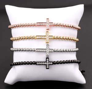 Gold T.M.J bead bracelet with luxury CZ diamond cross charm, featuring macrame design and stylish bead details.