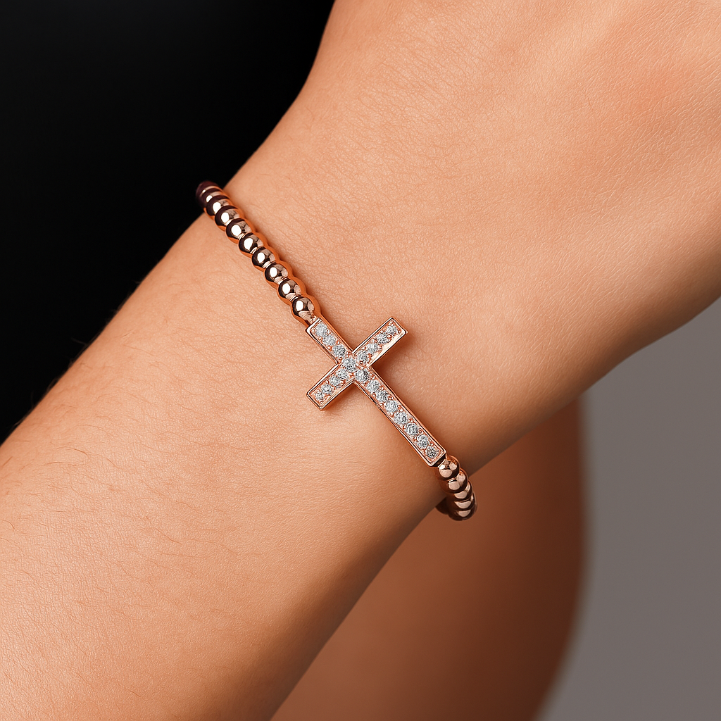 Gold bead bracelet with luxury CZ diamond cross charm and macrame design by T.M.J, stylish beaded jewelry accessory.