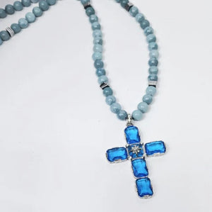 Large silver cross pendant with Austrian crystals on an aquamarine beaded necklace by T.M.J, featuring intricate gemstone details.