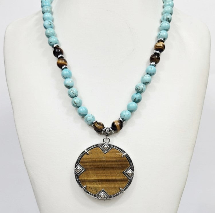 Large silver tiger eye pendant on turquoise and tiger eye beaded necklace, showcasing natural gemstone details and craftsmanship.