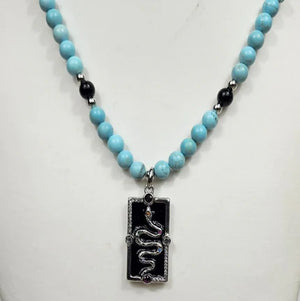 Silver enamel snake dog tag pendant from T.M.J on a vibrant turquoise beaded necklace.