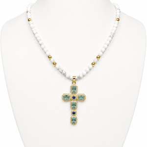 Silver and gold-plated beaded necklace with cross pendant featuring aquamarine crystals and faceted howlite beads.
