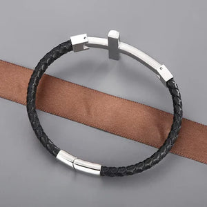 T.M.J leather bracelet featuring flat braided gold leather and a large cross pendant, stylish accessory for men and women.