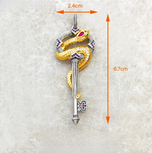 Silver and gold plated snake pendant with key and crystal accents, featuring detailed design and shiny finish.