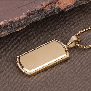 Silver or gold dog tag pendant with a single zirconium stone, featuring a sleek T.M.J brand design.