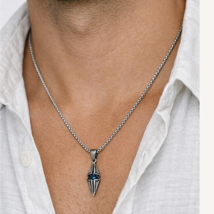 T.M.J Vesper steel spike pendant with antique finish and blue CZ accent, featuring a bold, edgy design.