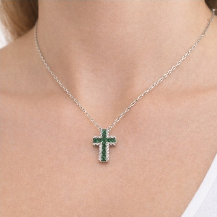 Sterling silver cross necklace with green accents by T.M.J, featuring a religious design on a delicate chain.