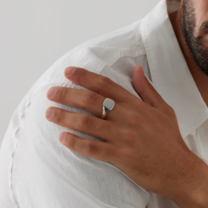 Men's sterling silver signet ring from T.M.J, featuring a polished, classic design on a smooth silver band.