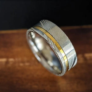 Helios 1 men's Damascus steel and gold inlay stainless steel ring by T.M.J displayed on a neutral background.