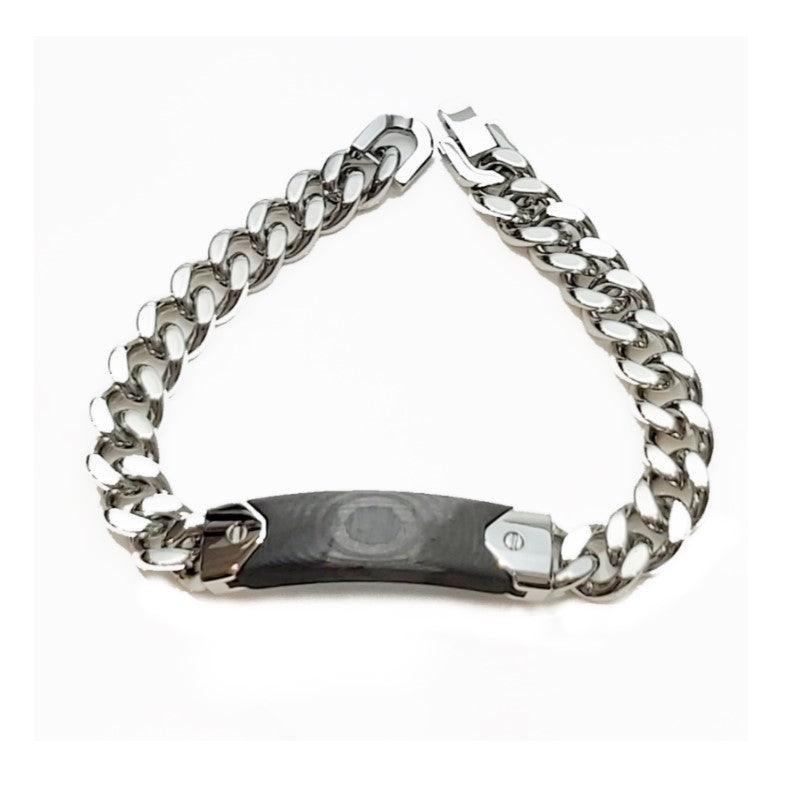 Black carbon fiber and stainless steel curb link bracelet by T.M.J, showcasing sleek, modern design with polished metal and textured fiber.