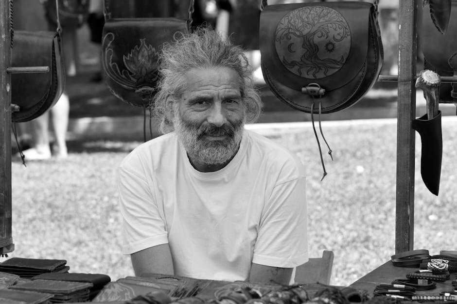 Leather artisan working on a men's leather accessory at a workbench