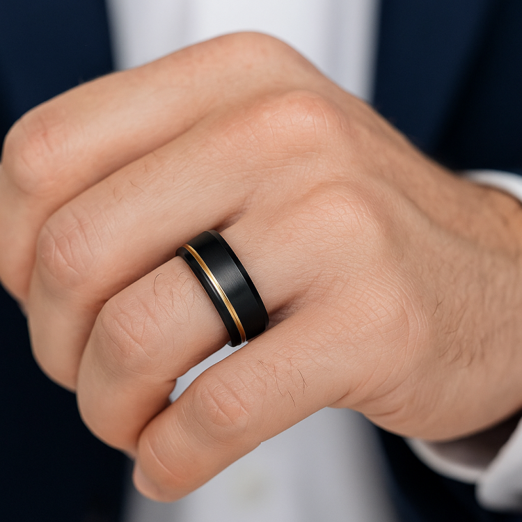 Black Zirconium ring with gold inlay on a person's finger, featuring a satin-brushed finish and polished beveled edges.