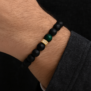 Black faceted agate and green tiger eye beaded bracelet with gold pavé spacer on wrist.