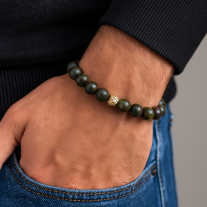 Bloodstone and gold plated silver bracelet with 10mm bloodstone beads showcasing deep green hues and red specks, worn on a wrist against a fabric background.