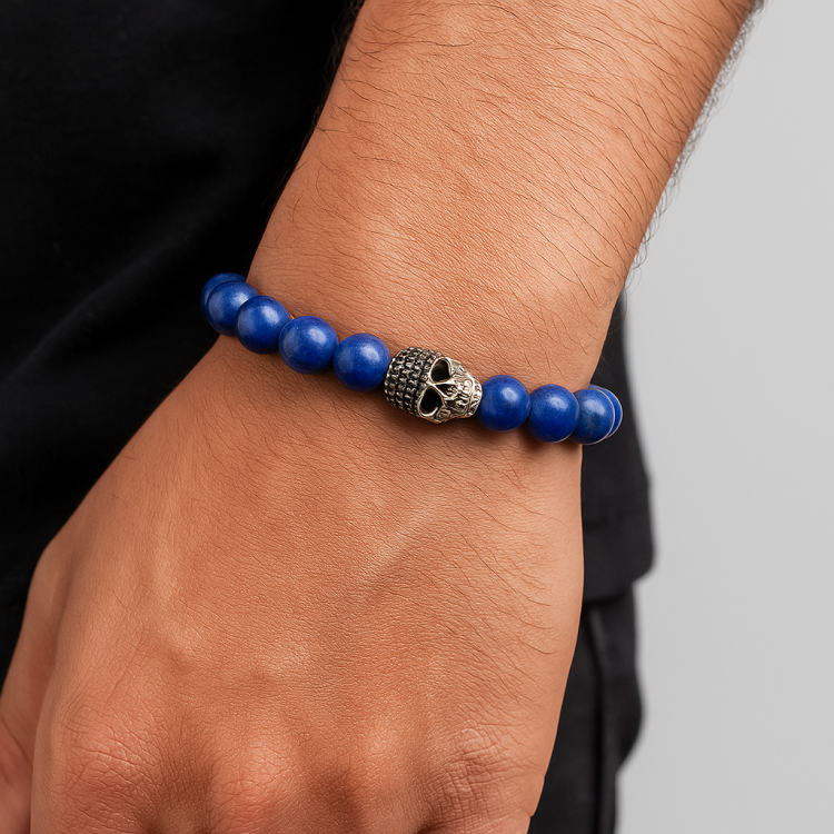 Blue Lapis Lazuli bracelet with silver skull bead, handcrafted elegance.