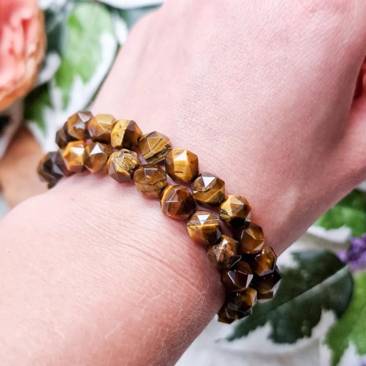 Multi-faceted Tiger Eye bead bracelet on wrist with golden-brown sheen.