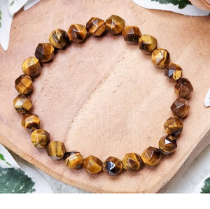 6–10mm Multi Faceted Tiger Eye Bead Bracelet with golden-brown sheen on wood background.
