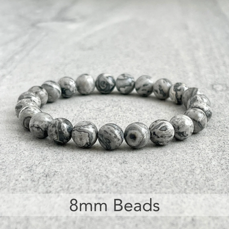 Natural Gray Jasper Beads Bracelet with 8mm beads on a stone surface.