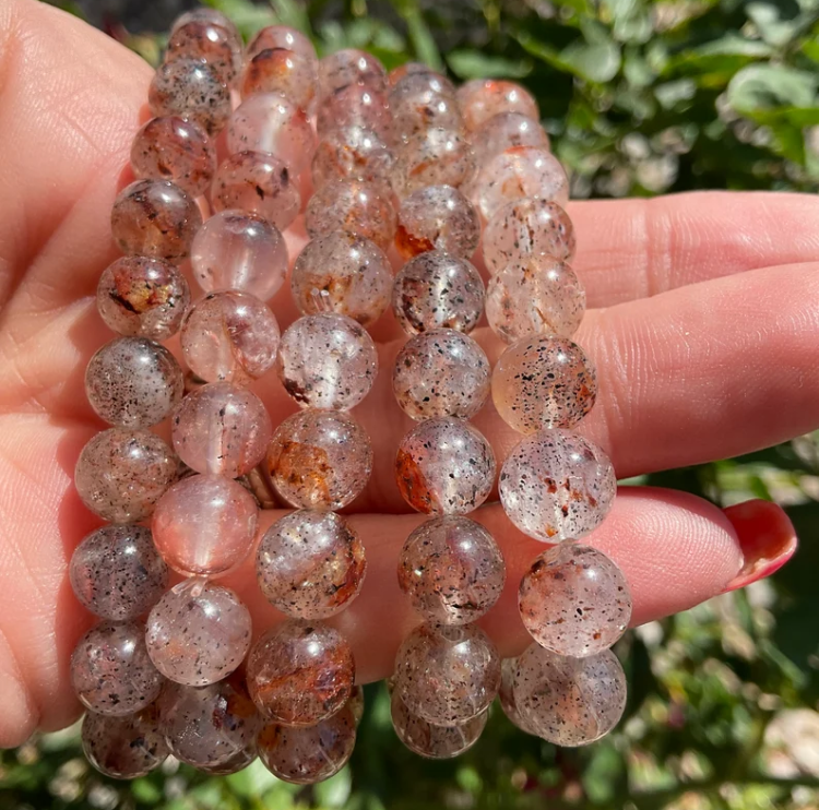 Mica Quartz Crystal beaded bracelet with shimmering reflective beads held in hand.