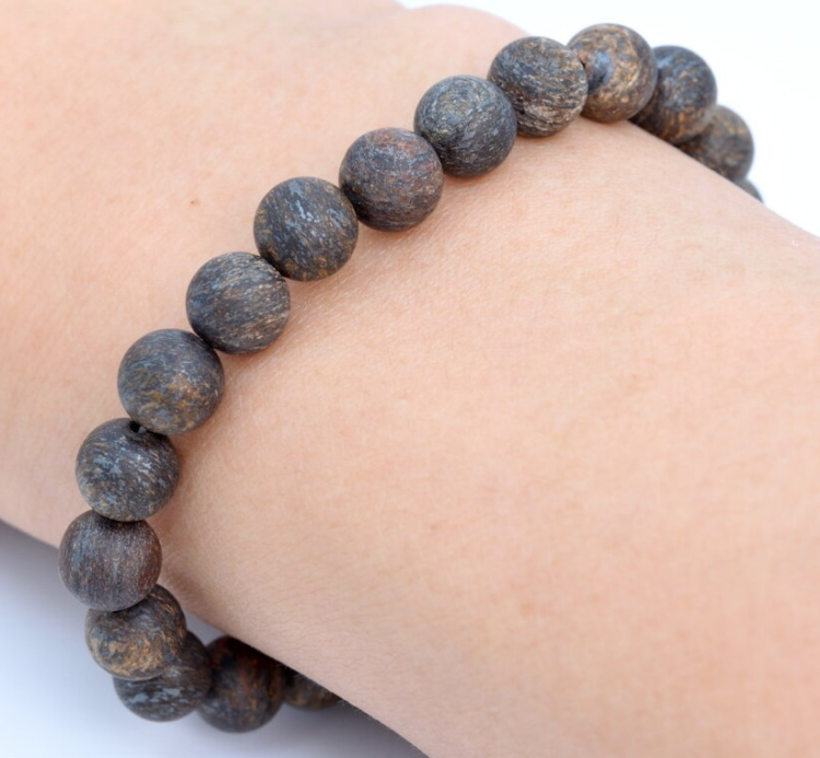 Natural matte bronzite stone beaded bracelet on wrist, showcasing soft texture and earthy tones.