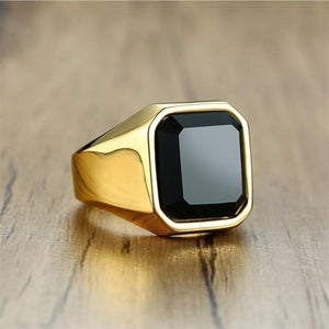 Stainless steel signet ring with matte finish and black stone centerpiece.