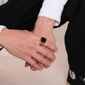 Stainless steel signet ring with black stone on hand.
