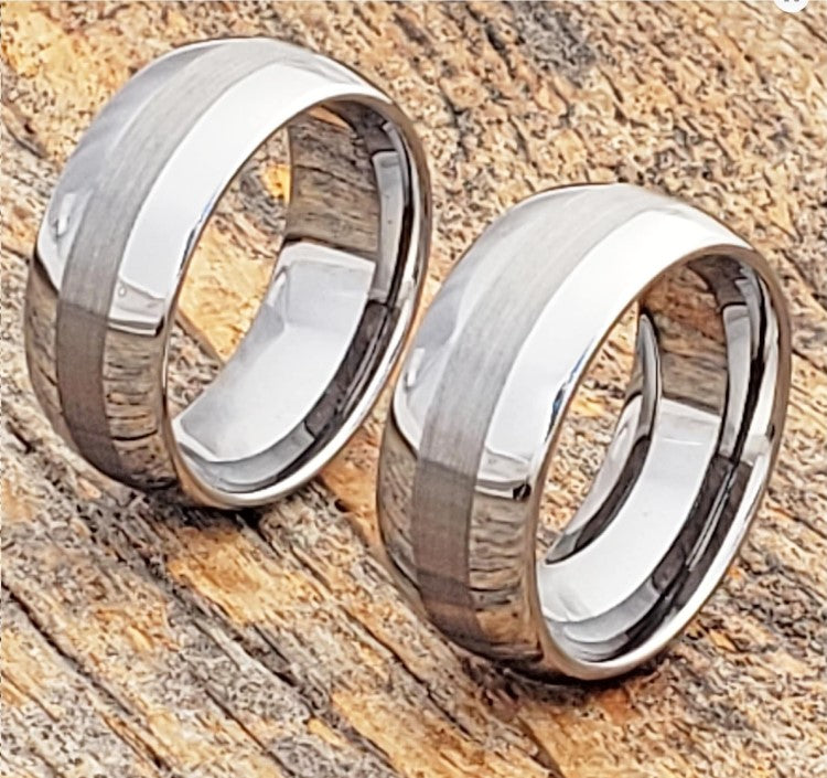 Silver tungsten carbide rings with satin center and polished edges on wooden surface.