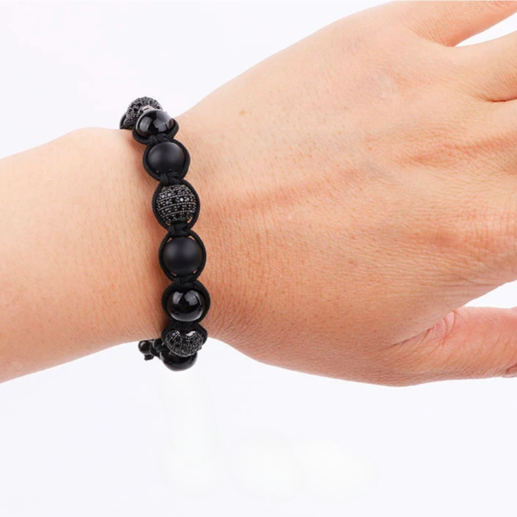 Beaded macrame bracelet featuring natural onyx and tiger eye stones, handmade by T.M.J, showcasing intricate beadwork and earthy tones.