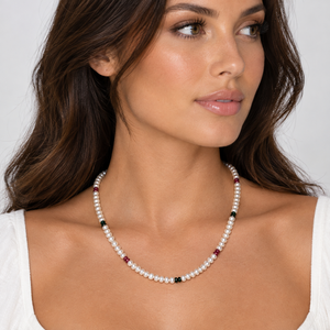 Model wearing the white button freshwater pearl necklace with faceted ruby and emerald-coloured stones