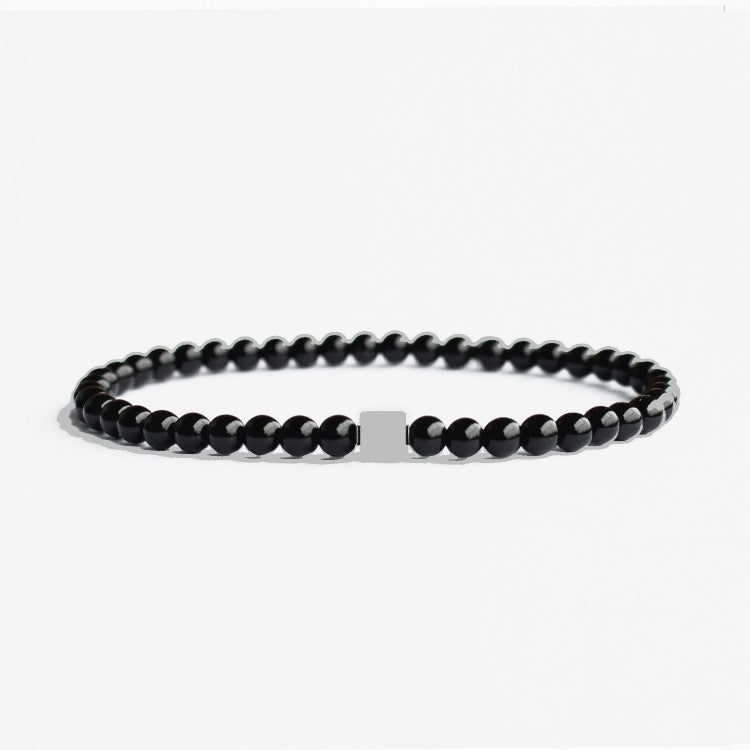 Black matte onyx and stainless steel bead bracelet from T.M.J, featuring 17cm, 4mm beads, stylish and durable accessory.
