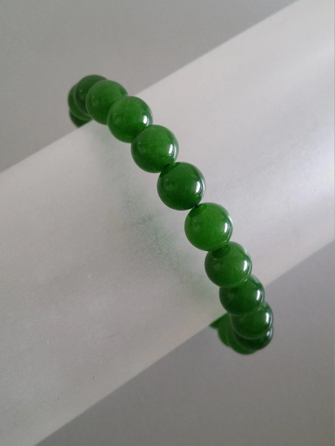 Green Jadeite beaded bracelet by T.M.J with 6mm round beads, stylish and natural-looking jewelry accessory.
