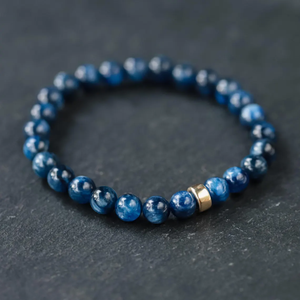Dark blue Kyanite crystal beaded bracelet with 7.5mm round beads, crafted by T.M.J, shown on a plain background.
