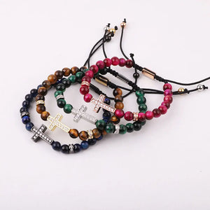 Natural 6mm tiger eye beaded macrame bracelet with CZ cross charm, featuring brown and gold tones and T.M.J branding.