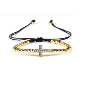 Gold bead bracelet with a luxury CZ diamond cross charm, macrame-style T.M.J beaded bracelet for a stylish, elegant look.