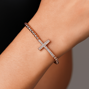Gold bead bracelet with luxury CZ diamond cross charm and macrame design by T.M.J, stylish beaded jewelry accessory.