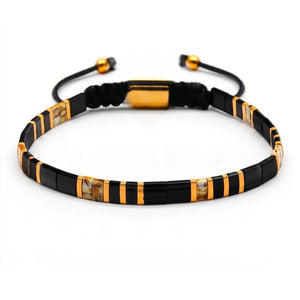 T.M.J Tila Link Macrame Bracelet with white and gold Miyuki Tila beads, featuring intricate beadwork and adjustable cord.
