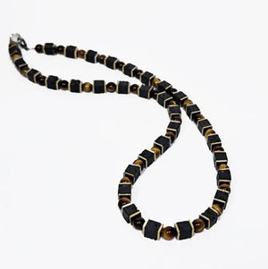 Beaded necklace featuring lava and tiger eye stones, 50cm length, by T.M.J, with natural stone details and textured beads.