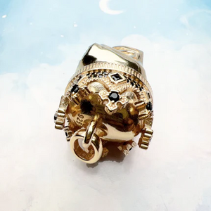 Large silver and gold-plated skull pendant with crown on blue tiger eye beaded necklace by T.M.J, close-up view of the detailed jewelry.