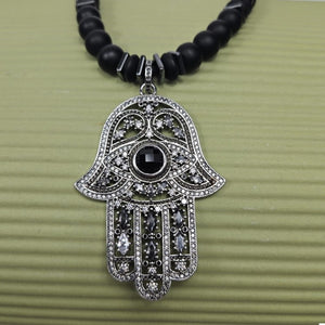 Large silver Hand of Hemsa beaded necklace by T.M.J with Austrian crystals and matte onyx beads, featuring a striking pendant.