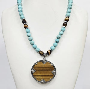 Large silver tiger eye pendant on turquoise and tiger eye beaded necklace, showcasing natural gemstone details and craftsmanship.
