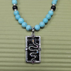 Silver enamel snake dog tag pendant on a turquoise beaded necklace, stylish and unique jewelry by T.M.J.