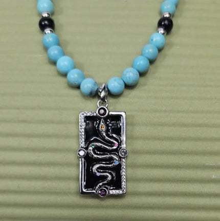Silver enamel snake dog tag pendant on a turquoise beaded necklace, stylish and unique jewelry by T.M.J.