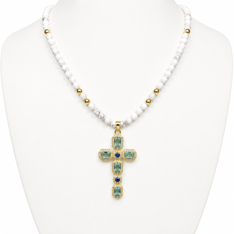 Silver and gold-plated beaded necklace with cross pendant featuring aquamarine crystals and faceted howlite beads.