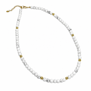 Silver and gold-plated beaded necklace with a cross pendant featuring aquamarine crystals on faceted howlite beads.